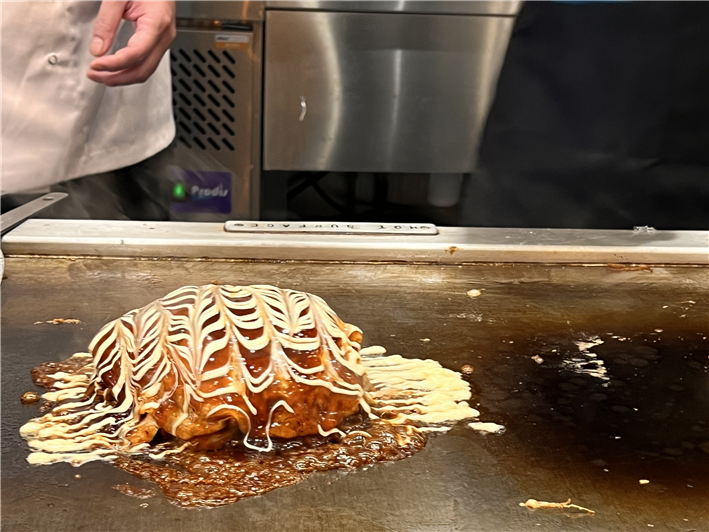 okonomiyaki being finished on hotplate